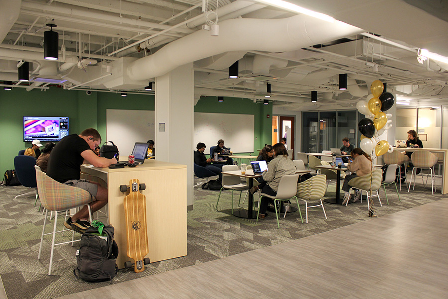 A diverse group of individuals engaged in discussion while seated at tables in a new lounge in BHEE